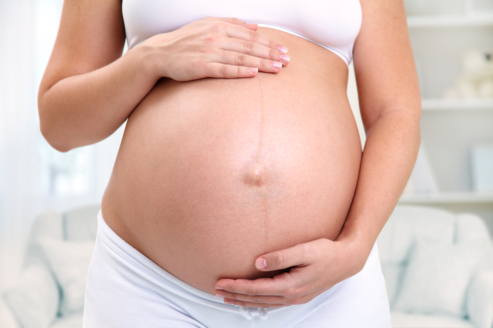 Woher kommt die dunkle Linie am Bauch von Schwangeren Frauen?